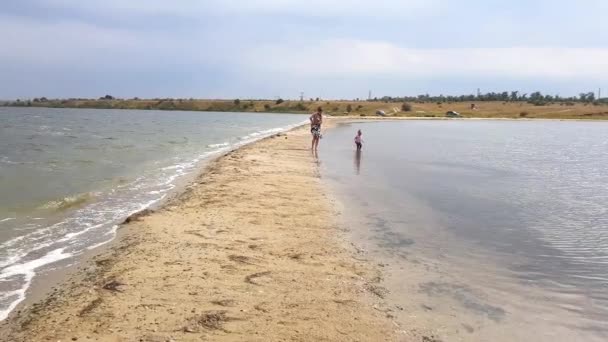 Schöne Aussicht auf Familie zu Fuß entlang der Spucke. Mutter und kleine Tochter spazieren im Frühherbst am Spieß — Stockvideo