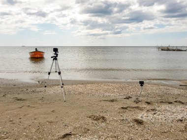 Two action films will capture the time-lapse of the seascape with an old orange rescue boat at sea near the shore anchored with the inscription rescue in Ukrainian on the deck. clipart