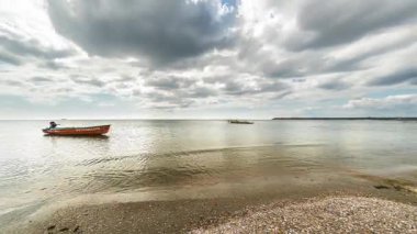 Erken sonbaharda sakin havalarda turuncu bir kurtarma teknesi ile deniz üzerinde kamerakalın bulutların 4k timelapse çalışan