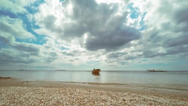 4K timelapse execução de nuvens grossas da câmera sobre o mar com um barco de resgate laranja em clima calmo no início do outono — Vídeo de Stock