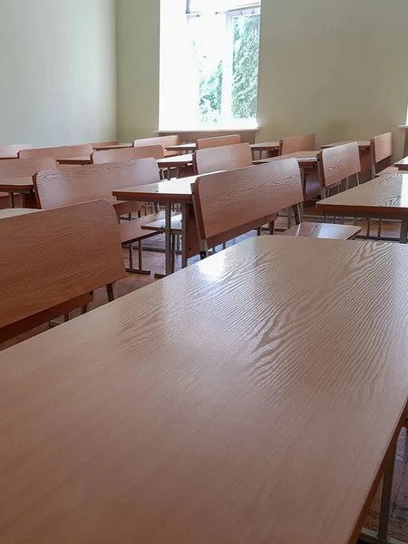 Aula escolar con escritorios de tres filas y grandes ventanales. Audiencia estudiantil con escritorios anchos en tres filas y una gran ventana . — Foto de Stock