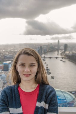 Londra'da bir dönme dolap kabin ayakta genç güzel sevimli kız görünüyor. London Eye genç güzel kız.