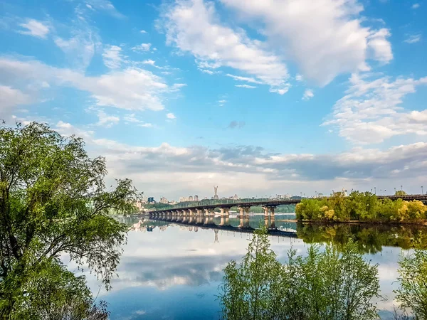 Široká řeka Dnieper s mostem po východu slunce s nádherními mraky — Stock fotografie