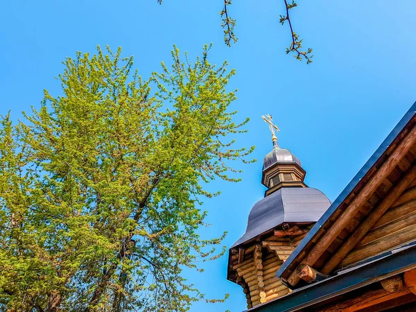 Temple orthodoxe en bois et arbres contre le ciel au printemps . — Photo