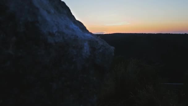 Stenkors på toppen av ett berg mot en solnedgång. Korsa på en solnedgång bakgrund. Stenkräm på berget vid solnedgången — Stockvideo