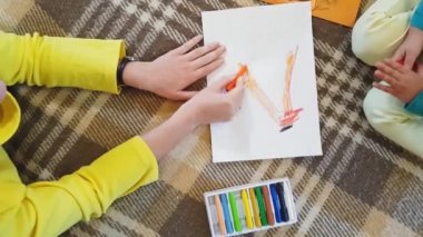 Genç anne ve kız yağ rengi pastel yazılar çiziyor. Beyaz kağıtlara sonbahar yazılıyor ve başvuru yapılıyor. Annesi olan küçük bir kız, beyaz kağıt üzerine sonbahar yazıtları çiziyor..