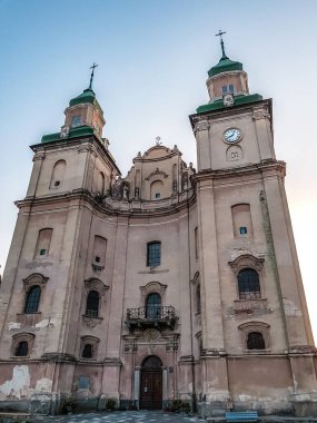 Gün batımından önce arkasında mavi bir gökyüzü olan eski bir kilise.