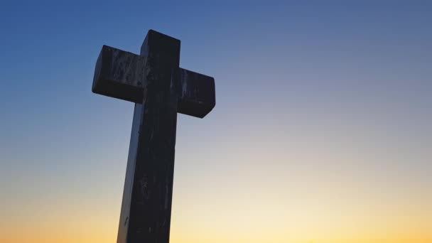 Stone cross on top of a mountain against a sunset. Cross on a sunset background. Stone crem on the mountain at sunset — Stock Video