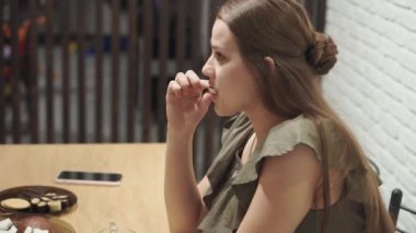 Kafeler ve restoranlar, evcillik, iletişim, akrabalar konsepti - iki genç kız kardeş akşam evde mutfak masasında oturmuş şekerlerle çay içerek sohbet ediyorlar. Konuşan kadınlar.