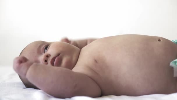 Säugling, Mutterschaft, Entwicklung, Kindheit, Ausbildung, Pädiatrie, Medizin und Gesundheitskonzept - nackte Neugeborenenlügen aus nächster Nähe wecken Mutter legt Baby in Body-Anzug. auf weißem Hintergrund. — Stockvideo