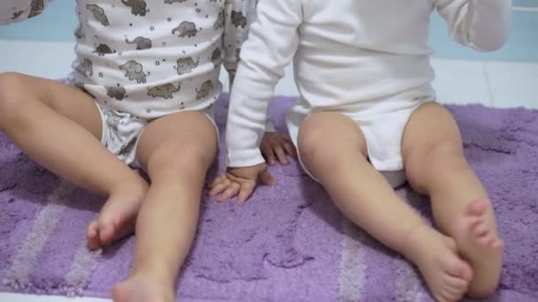 Gyermekkor, higiénia, orvostudomány és egészség koncepció - két kisgyermek testvér testvér testvér fiú és lány ikrek azonos korú mossák fogukat pizsamában ül a fürdőszoba padlóján alvás után. — Stock videók