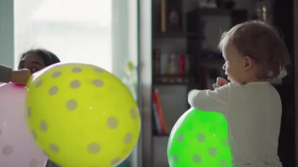 Niños, celebración, cumpleaños, familias numerosas, juegos y concepto de entretenimiento: niños pequeños y adolescentes de diferentes edades y nacionalidades juegan con globos en una habitación espaciosa contra la ventana . — Vídeos de Stock