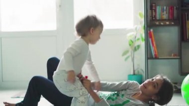Çocuklar, kutlama, doğum günü, büyük aileler, oyunlar ve eğlence konsepti - farklı yaş ve milletten çocuklar ve gençler pencerenin önündeki geniş odada balonlarla oynuyorlar..