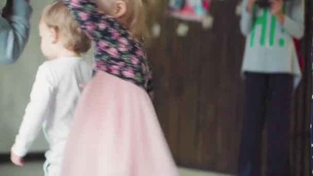 Kinderen, viering, verjaardag, grote gezinnen, spelletjes en entertainment concept - jonge kinderen en tieners van verschillende leeftijden en nationaliteiten spelen met ballonnen in ruime kamer tegen het raam. — Stockvideo