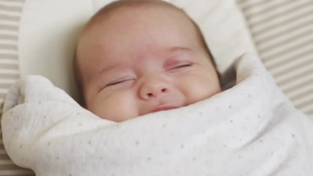 Nfancy, dzieciństwo, rozwój, medycyna i koncepcja zdrowia - Close-up top view portret obudzonego noworodka leżącego na bujanym krześle pod białym kocem. — Wideo stockowe