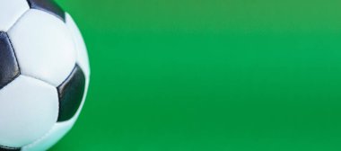 Spor, futbol, müsabakalar, fiziksel kültür, sağlıklı yaşam tarzı konsepti - düz yeşil arka plan kromakey kopyalama alanı üzerinde yakın plan siyah ve beyaz klasik futbol topu pankartı