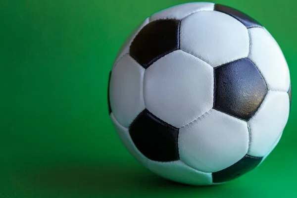 Sport, football, competitions, physical culture, healthy lifestyle concept - banner of flat lay close-up black and white classic soccer leather ball on a plain green background chromakey copy space