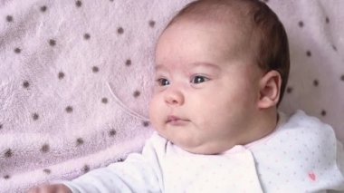 bebeklik, çocukluk, gelişim, tıp ve sağlık konsepti - yeni doğmuş tombul bebeğin yukarıdan yakından bakışı beyaz vücut giysisi giymiş uyanık bebek pembe arka planda sırtüstü uzanan suratlar