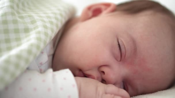 Infanzia, infanzia, sviluppo, medicina e concetto di salute volto primo piano di neonato paffuto bambino addormentato sdraiato sullo stomaco occhi aperti e sorriso coperto di coperta sul letto su sfondo bianco. — Video Stock