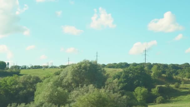 Doprava, cestování, silnice, železnice, krajina, koncept smilstva - pohled z okna rychlovlaku na krajinu krásné polní cesty s auty a lesy za jasného dne se vzácnými bílými mraky — Stock video