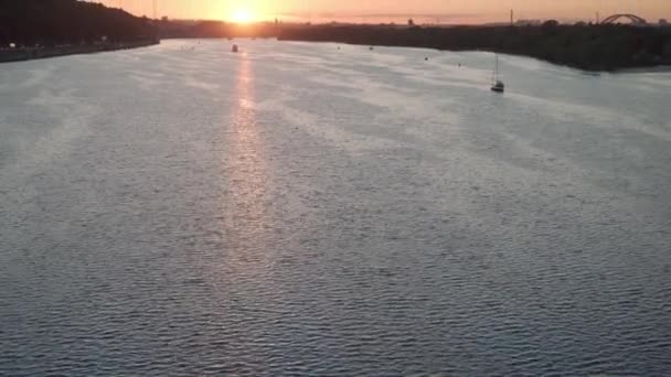 Transprt, embalses, viajes, concepto de navegación - levantamiento aéreo desde el puente de altura estanque de remo con barcos barcos yates y otros buques acuáticos turísticos en el ancho río Dnipro en Kiev al atardecer. — Vídeo de stock