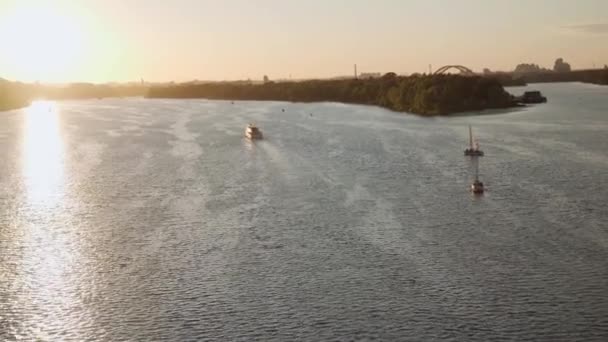 Transprt, přehrady, cestování, navigační koncepce - letecký průzkum z výšky mostu ower rybník s loděmi lodí jachty a jiné turistické vodní lodě na široké řece Dnipro v Kyjevě při západu slunce. — Stock video