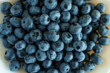 meyve ve yulaf, vitamin, sağlıklı yiyecek ve içecek, geleneksel tıp, gastronomi konsepti - mor ve mavi böğürtlenlerin beyaz tabakta dizilişi veya parlak sarı arka plan fotokopi alanı üzerinde kap