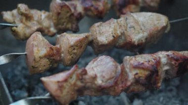 Kafeler ve restoranlar, yemek pişirme, piknik, doğu mutfağı konsepti yakın plan domuz eti ve kızarmış kömürde ızgarada kızartılmış tavuk kebabı. Açık havada mangal yapan adamın eli kapağı kapatır.
