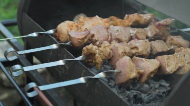 Kafeler ve restoranlar, yemek pişirme, piknik, doğu mutfağı konsepti yakın plan domuz eti ve kızarmış kömürde ızgarada kızartılmış tavuk kebabı. Açık havada barbekü yapan erkeklerin elleri kapağı açar.