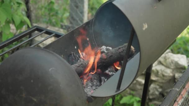 Koken, oosterse keuken, bosbranden, brandstichting concept - vuur en kolen in zwart metalen rooster voor het roken en bakken van vlees en groente voedsel in de hitte van de natuur met rook. — Stockvideo