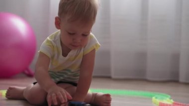 Çocukluk, oyunlar, yetiştirme ve geliştirme konsepti - küçük çocukların genel planı aynı yaşta erkek ve kız çocuklarının oyun odasında oyuncak motorlu arabalarla yarış pisti yapımcılarıyla oynuyorlar.