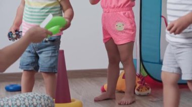 Çocukluk, oyunlar, yetiştirilme ve gelişim konsepti - annesiyle aynı yaşta küçük çocukların genel planı çocuk oyun odasında gökkuşağı renginde çok renkli halkalar piramidiyle oynuyor