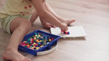 Çocukluk, annelik, oyunlar, terbiye ve gelişim konsepti - yakın plan geniş anne, çocuk oyun odasında yeni doğmuş küçük kız ve erkek çocuk aynı yaşta çok renkli mozaiklerle neşe içinde oynuyor