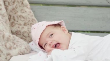 bebeklik, çocukluk, gelişme, yaz tatili, tıp ve sağlık konsepti - Panama 'da sırıtan bir bankta karnı üzerinde uzanan uyanık yeni doğmuş bebek portresi