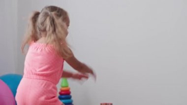 Çocukluk, oyunlar, yetiştirme ve geliştirme konsepti - küçük çocukların genel planı aynı yaşta erkek ve kız çocuklarının oyun odasında oyuncak motorlu arabalarla yarış pisti yapımcılarıyla oynuyorlar.