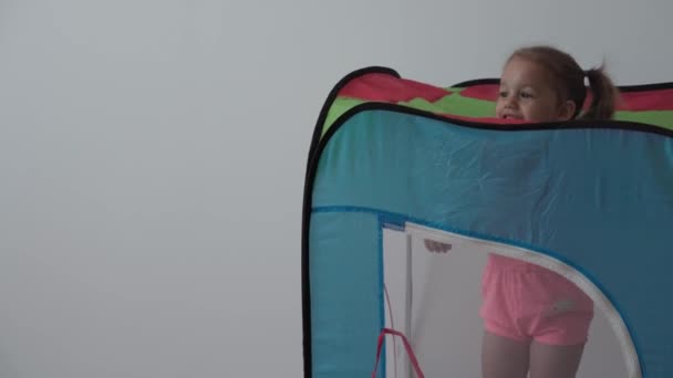 Lapsuus, pelit, kasvatus ja kehitys konsepti yleinen suunnitelma pienten lasten poika ja tyttö samanikäisiä leikkivät lasten lelu värikäs teltta teltta leikkihuone. — kuvapankkivideo