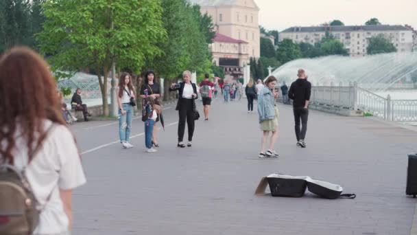 Muzyka, zarobki, darowizny, koncepcja rozrywki - uliczne muzycy dwóch facetów z beatbox gitara i bęben z urządzeń audio grać i śpiewać w parku w pobliżu jeziora z fontannami w letni wieczór zachód słońca. — Wideo stockowe