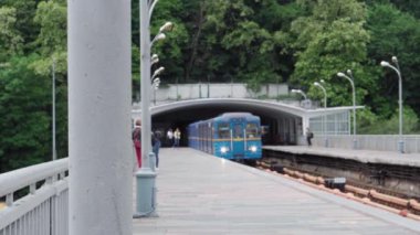 Şehir ulaşımı, seyahat, altyapı, metropol konsepti. Dinyeper Nehri üzerindeki bir köprüden mavi ve sarı bir metro geçiyor..