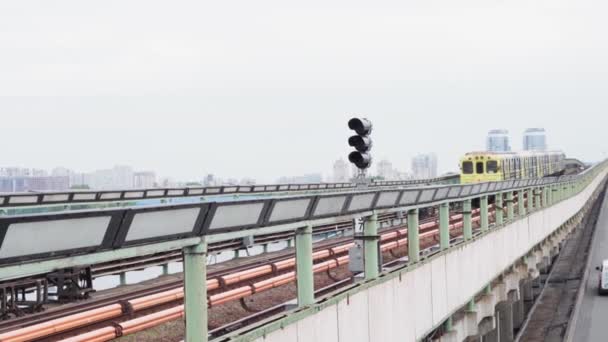 Şehir ulaşımı, seyahat, altyapı, metropol konsepti. Dinyeper Nehri üzerindeki bir köprüden mavi ve sarı bir metro geçiyor.. — Stok video