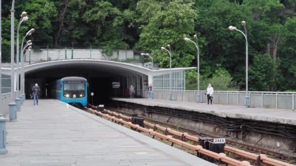 城市公共交通、旅游、基础设施、大都市的概念- -一辆蓝色和黄色的地铁通过第聂伯河上一座桥上的地面站. — 图库视频影像