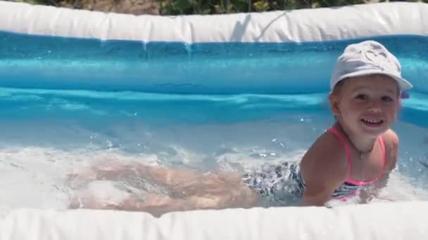两个小孩，男孩和女孩白种人一样大的欧洲斯拉夫模样，夏天在游泳池里快乐地沐浴和嬉戏，泼洒着水，生活方式设计。活动自然休闲。慢动作 — 图库视频影像