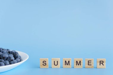 meyve ve sebze, vitamin, sağlıklı yiyecek ve içecek, geleneksel tıp, gastronomi konsepti - beyaz tabakta mor böğürtlen yerleşimi ve mavi arkaplan fotokopi alanı üzerine yazı