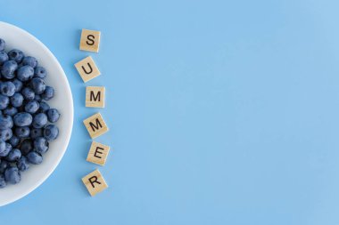 meyve ve sebze, vitamin, sağlıklı yiyecek ve içecek, geleneksel tıp, gastronomi konsepti - beyaz tabakta mor böğürtlen yerleşimi ve mavi arkaplan fotokopi alanı üzerine yazı