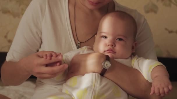 Macierzyństwo, dzieciństwo, karmienie, jedzenie, rodzina, koncepcja pielęgnacji - pierwszy plan noworodka nago na jawie śpiącego 6-miesięczne grymaki niemowlęce w ramionach młodych mam z jasnym promieniem słońca na twarzy rano — Wideo stockowe