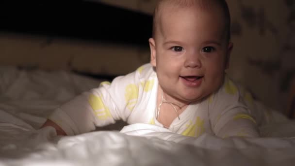 Copil, copilărie, dezvoltare, medicină și conceptul de sănătate - prim plan al nou-născutului gol treaz dormind grimacele bebelușului de 6 luni întinse pe stomac cu raze strălucitoare de soare pe față dimineața — Videoclip de stoc