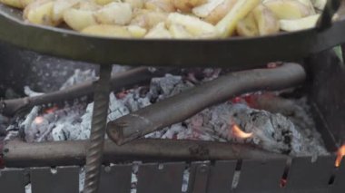 Kafeler ve restoranlar, yemek pişirme, piknik, doğu mutfağı konsepti - kamp ateşi üzerinde yemek pişirmek için büyük kızartma tavasında yakın plan patates kızartma.