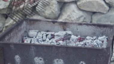 Kafeler ve restoranlar, yemek pişirme, piknik, doğu mutfağı konsepti - yakın plan sosisler ızgarada ızgarada kızartılmış ve ızgara kömürde kızartılmış. Dışarıdaki erkeklerin elleri yemeğe hazırlanıyor..