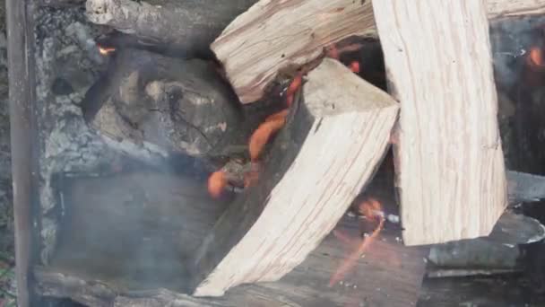 Cucina, cucina orientale, incendi boschivi, incendio doloso - accensione fuoco e carboni nella griglia metallica nera per affumicare e friggere carne e cibo vegetale in calore di sfondo esterno di pietre bianche — Video Stock