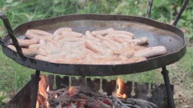 Kafeler ve restoranlar, yemek pişirme, piknik, doğu mutfağı konsepti - büyük bir kızartma tavasında sosis pişirmek için açık havada sigara ve kızarmış kömür..