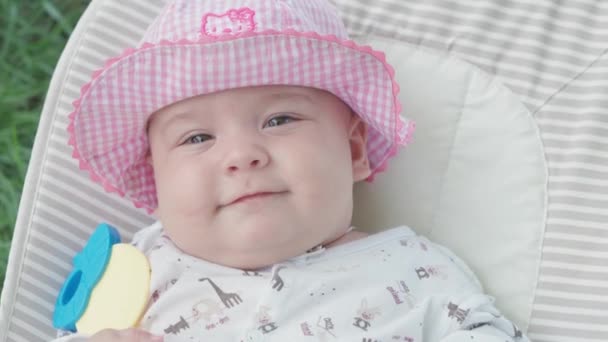 Infância, infância, desenvolvimento, férias de verão, medicina e conceito de saúde - Close-up top view retrato de bebê recém-nascido acordado menina de cinco meses de idade deitado em fundo cadeira de balanço de grama verde — Vídeo de Stock